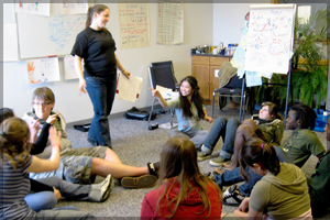 Group of teenagers in a room working together on a project.